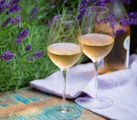 Love Provence, romantic picnic with glasses of cold French rose wine and purple lavender flowers in sunny summer garden