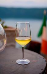 Glass of cold dry white wine served outdoor in cafe at night in Italy