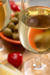 Glasses of dry fino sherry wine served with spanish tapas, manchego cheese, green olives, cheese crackers