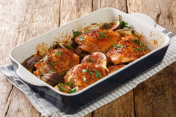 Rustic style chicken thighs baked with figs close-up in a baking dish on the table. horizontal