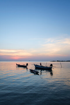 Small Fishing Boats In The Sea During Sunset