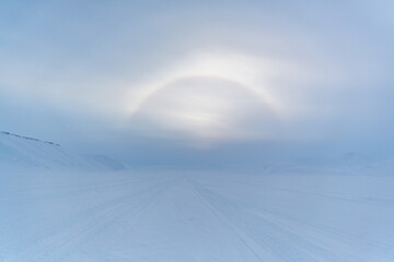 Halo effect on frosty Svalbard - ring of light visible around the svalbard sun. - 375860240