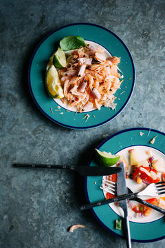 Leftover food on plates on a metal table.