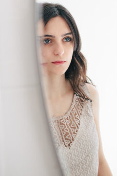 Reflection of young Mediterranean woman from mirror