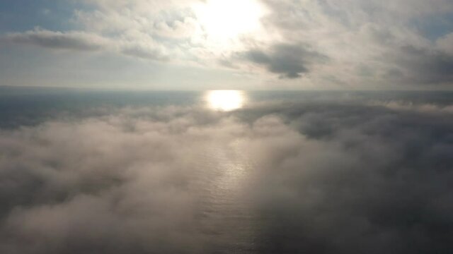 Aerial video over а morning calm sea and beautiful sunrise with low clouds