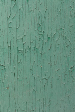A wood surface with faded aqua paint, crackled paint