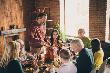 Photo of full family eight people gathering sit two small kids bearded father cut roasted turkey...