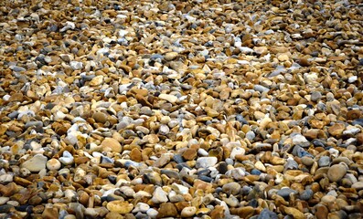 An empty pebble beach on the south coast of England. A random pattern of pebbles. No people. Plenty of copy space.