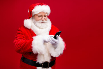 Portrait of his he nice attractive handsome focused Santa grandfather using gadget 5g service blog blogger post comment feedback isolated over bright vivid shine vibrant red color background