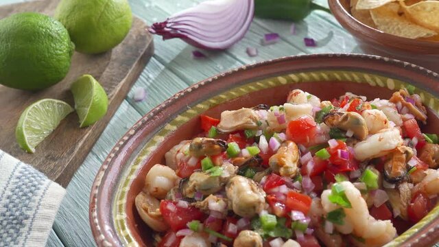 An authentic bowl of delicious seafood ceviche with shrimp and mussels.
