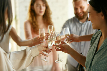 Happiness. People clinking glasses with wine or champagne. Happy cheerful friends celebrate holidays, meeting. Close up shot of smiling friends, lifestyle. Party at home or in restaurant, cafe.