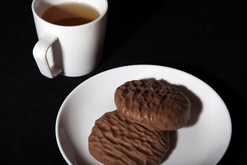 White cup of tea and plate with biscuits
