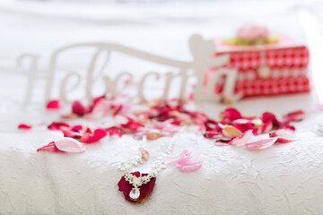 Decorations for the bride are spread among rose petals.,