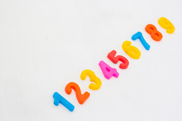 Colorful plastic numeral on white background. Learning numbers with fridge magnets. Arithmetic education in school