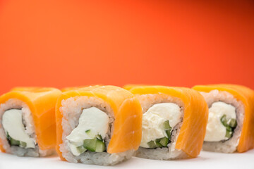 Close-up fresh sushi with fish, cucumber and rice with cheese, traditional japanese sushi. Selective focus, shallow depth of field