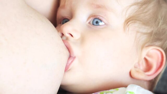 cute baby sucking mother's breast with milk Breastfeeding baby face