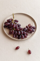 fresh juicy grapes on a plate on a light background