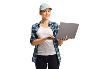 Young woman with a cap and a checkered shirt holding a laptop computer and looking at the camera