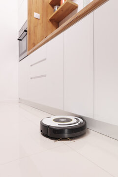 Robotic vacuum cleaner working on a kitchen floor