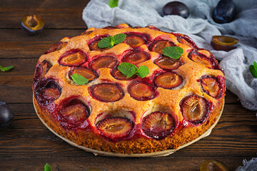 Delicious homemade plum pie on rustic background