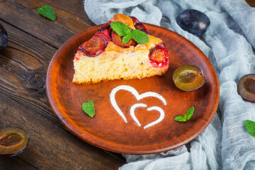 Delicious homemade plum pie on wooden background