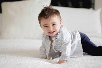 Fototapeta premium boy climbing on a big bed jumping 