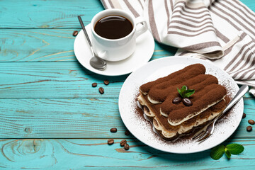 portion of Classic tiramisu dessert, cup of coffee and milk or cream on wooden background