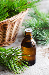 Pharmacy bottle with essential pine oil (extract, tincture, infusion). Old wooden background. Aromatherapy, spa and herbal medicine concept. Copy space.