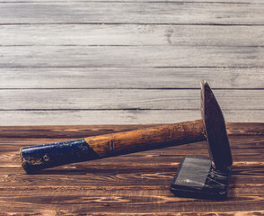 Old big hammer on a broken smartphone display.