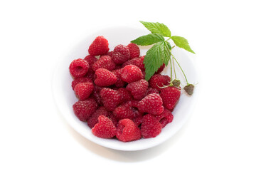 ripe raspberry berry on a white plate with a leaf close-up. isolate on a white background.
