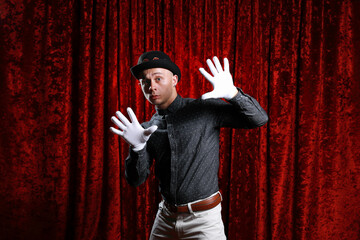 Young caucasian man in black bowler hat  with funny face and white gloves posing like master of...