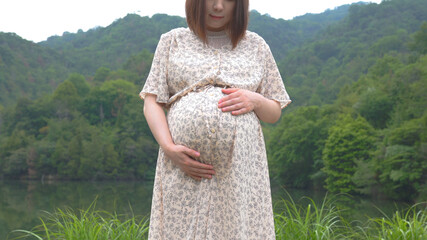 森の中に立つ日本人の妊婦さん
