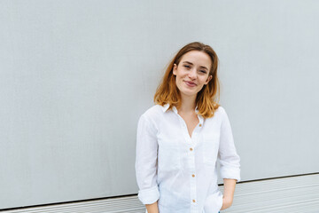 Cute young woman grinning as she looks at camera