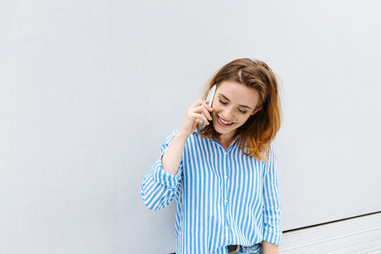 Young woman smiling as she chats on her mobile