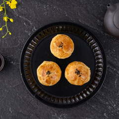 Moon cake yolk pastry, mooncake for Mid-Autumn Festival holiday, top view design concept on dark wooden table with copy space, flat lay, overhead shot