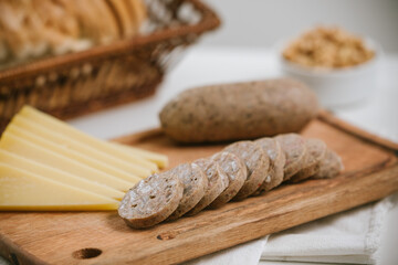 Queso de cerdo codeguín en tabla de madera con quesos y pan, acompañado de vino blanco