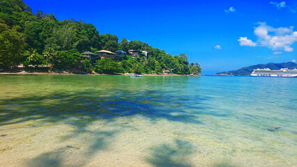 Quiet Paradise Beach located near Patong, in Phuket Island Thailand with golden sand, azure water and palm trees. 