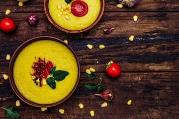 Corn cream soup with fresh vegetables, herbs and spices