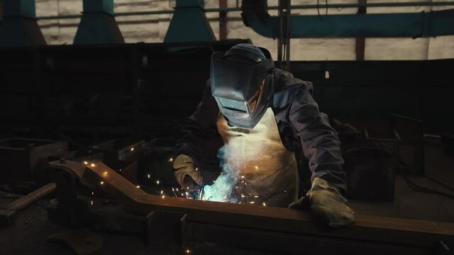 Manufacture of Railcar or Carriage, Train Wagon Production, Factory Workers are Welding in Protective Helmets and Glasses, Beautiful Epic Shot, Dolly Out, Slow Motion