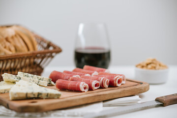 jamón crudo en tabla con queso azul y vino tinto