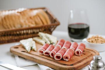 jamón crudo en tabla con queso azul y vino tinto