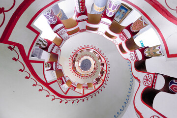 White round spiral staircase with white railings and various symbols top view