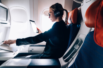 Serious woman using tablet in airplane