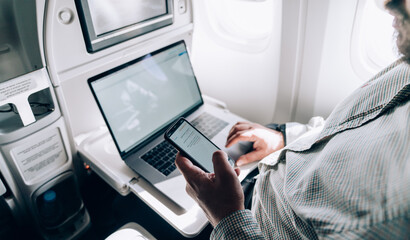 Man using smartphone during flight in airplane