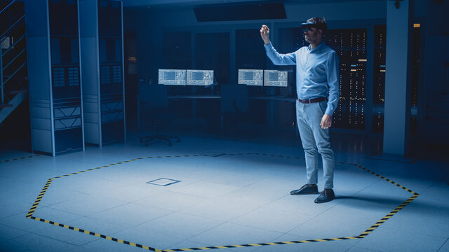 In 3D Content Creating Laboratory Engineer Wearing Professional Virtual Reality Headset Works and Gestures in Augmented Reality. Industrial Software Design Facility