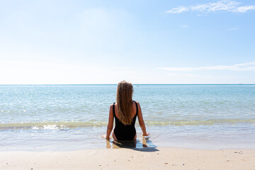 Fototapeta na wymiar Beautiful girl on the beach. Happy carefree young woman enjoying the sea