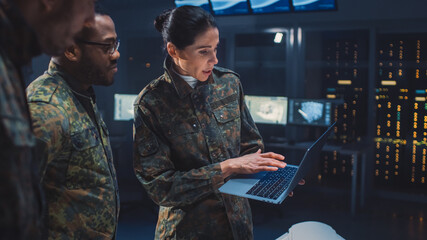 International Team of Military Personnel Have Meeting in Top Secret Facility, Female Leader Holds Laptop Computer Talks with Male Specialist. People in Uniform on Strategic Army Meeting - obrazy, fototapety, plakaty