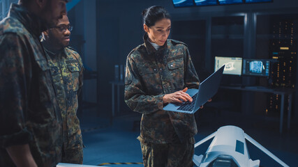 International Team of Military Personnel Have Meeting in Top Secret Facility, Female Leader Holds Laptop Computer Talks with Male Specialist. People in Uniform on Strategic Army Meeting - obrazy, fototapety, plakaty