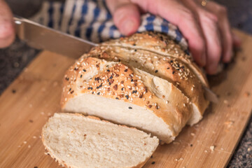 Homemade bread loaf being sliced with everything seasoning.  Baking bread popular during pandemic.