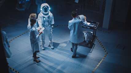 Team of Aerospace Scientists and Engineers Wearing White Coats have Discussion, Use Computers,...